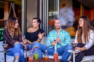Bạn bè hút shisha và uống cocktail tại quán bar shisha